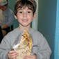 A young baker shows off his own matza.